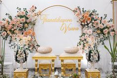 an arrangement of flowers and chairs in front of a wedding sign