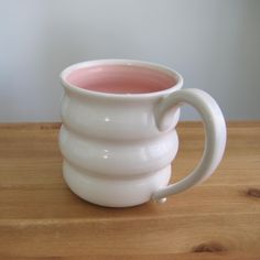 a white mug sitting on top of a wooden table