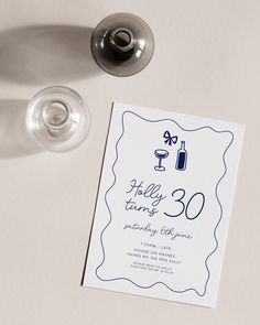 a white table with a wine glass and card on it that says hollywood turns 30