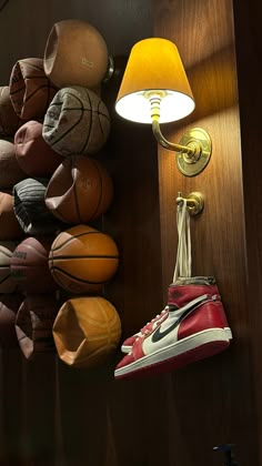 there is a lamp and basketballs hanging on the wall next to eachother