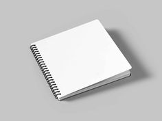 a white spiral notebook sitting on top of a gray surface