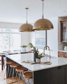 a kitchen with two pendant lights over the island