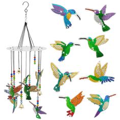 a group of colorful hummingbirds flying next to a wind chime with beads on it