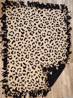 a leopard print rug with black ruffles on the bottom and an animal print design