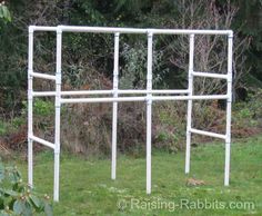 a white metal structure sitting on top of a lush green field