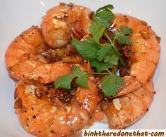 cooked shrimp with cilantro and parsley garnish on a white plate