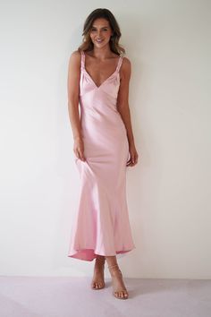 a woman in a pink dress posing for the camera