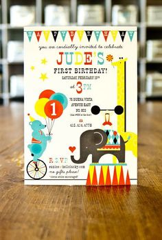 a birthday card with an elephant riding a bike and balloons in the air, on a wooden table