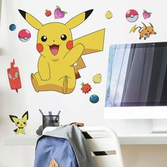 a child's room with a computer and pokemon wall decals