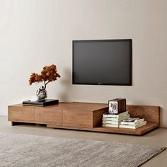 a flat screen tv mounted to the side of a wooden entertainment center in a living room