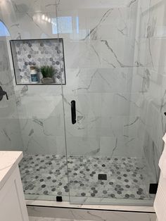 a walk in shower sitting next to a white sink