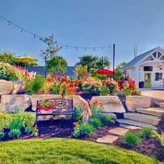 a garden with flowers and rocks in front of a house