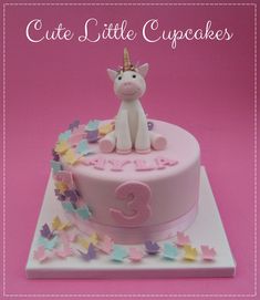 a birthday cake with a unicorn on top and butterflies around the bottom that says cute little cupcakes