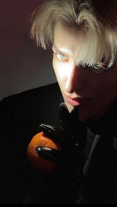 a man with blond hair holding an orange