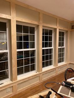 an empty room with several windows in the wall and hard wood flooring on the other side