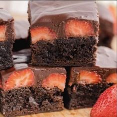 chocolate brownies with strawberries are stacked on top of each other