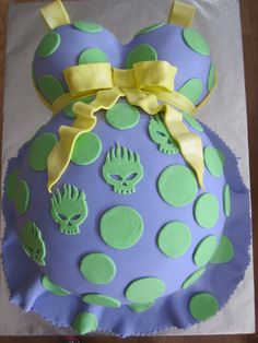 a cake with green and blue decorations on it's side, sitting on top of a table