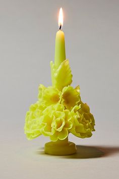 a yellow candle is lit in the shape of a flower