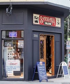 the outside of a restaurant with signs in front of it