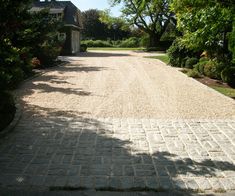 the driveway is made of bricks and gravel