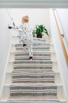 a toddler is climbing the stairs in his pajamas