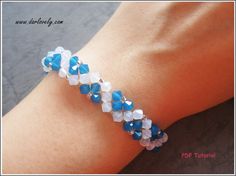 a woman's arm with a bracelet made out of blue and white glass beads