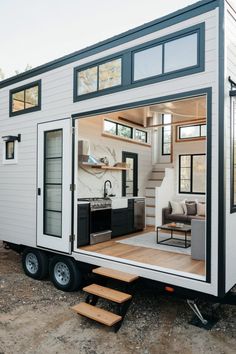 a tiny house on wheels with stairs leading up to it