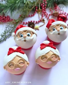 three plastic santa clause ornaments sitting on top of a table