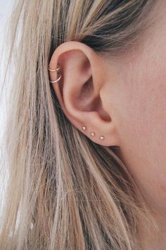 a close up of a person's ear with two small piercings on it