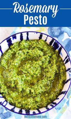 a bowl filled with pesto on top of a blue and white table cloth next to a