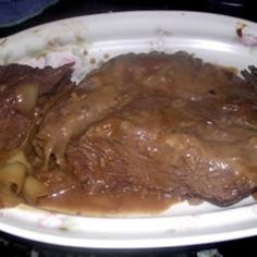 a white plate topped with meat covered in gravy