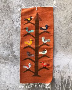 an orange wall hanging with birds on it