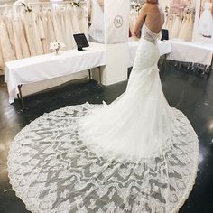 a woman in a wedding dress is looking at the bride's gown on display