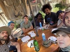 a group of people sitting around a wooden table