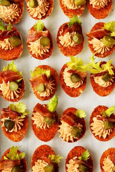 small appetizers are arranged in rows on a white surface, ready to be eaten