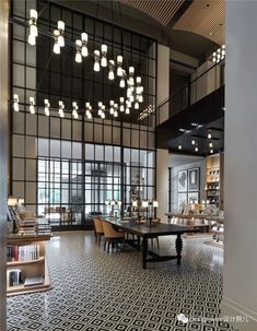 a large room with tables, chairs and bookshelves on the walls in front of windows