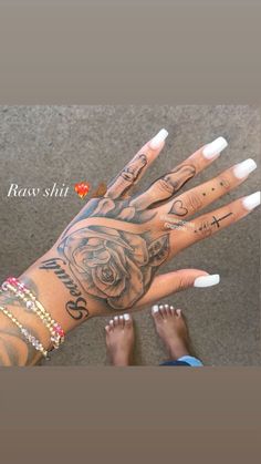 a woman's hand with tattoos on it and two fingers that have roses tattooed on them