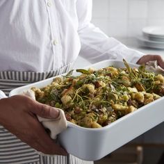 a person holding a dish with vegetables in it