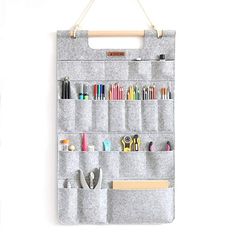 a wall hanging organizer with scissors, pens and pencils