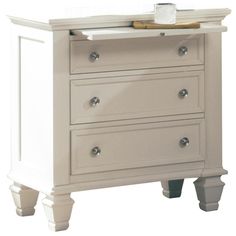 a white dresser with three drawers and a tray on top of it's drawer