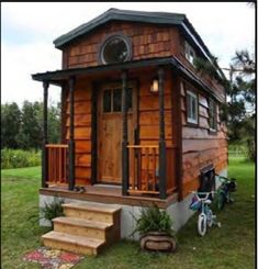 the tiny house is made out of wood and has stairs leading up to it's front door