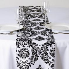 a black and white damask table runner on a dining room table with wine glasses