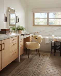 a bath room with a chair a sink and a mirror on the wall in front of a window