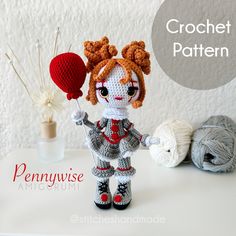 there is a crochet doll that is holding a ball of yarn and knitting needles