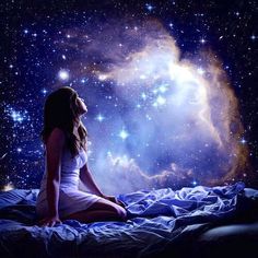 a woman sitting on top of a bed in front of a night sky filled with stars