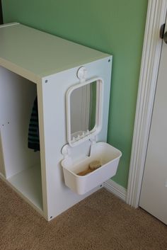 a cat litter box in the corner of a room with green walls and carpeting