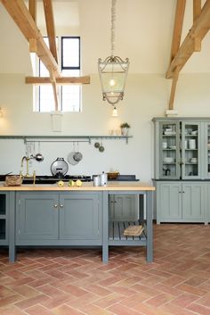 a kitchen with gray cabinets and an island in the middle of it's floor