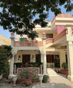 the front entrance to a house with flowers and trees