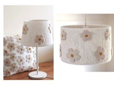 a lamp that is on top of a table next to a pillow with flowers on it