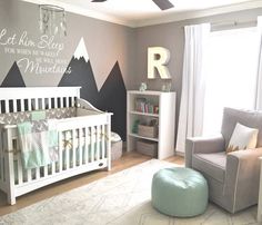 a baby's nursery room with mountains painted on the wall and a crib